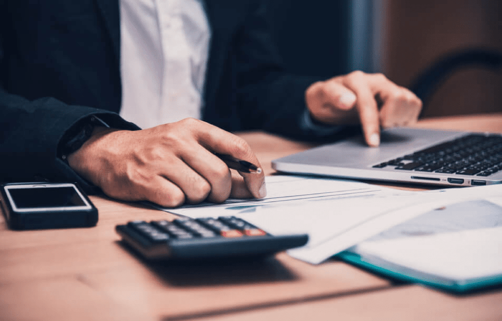 Persona trabajando con ordenador y calculadora